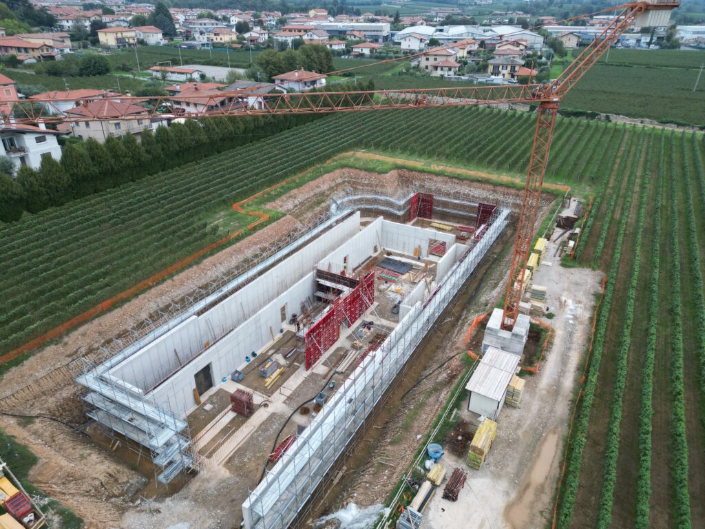Cantiere cantina ad Adro: prospetto della struttura tra i filari, ripresa da drone