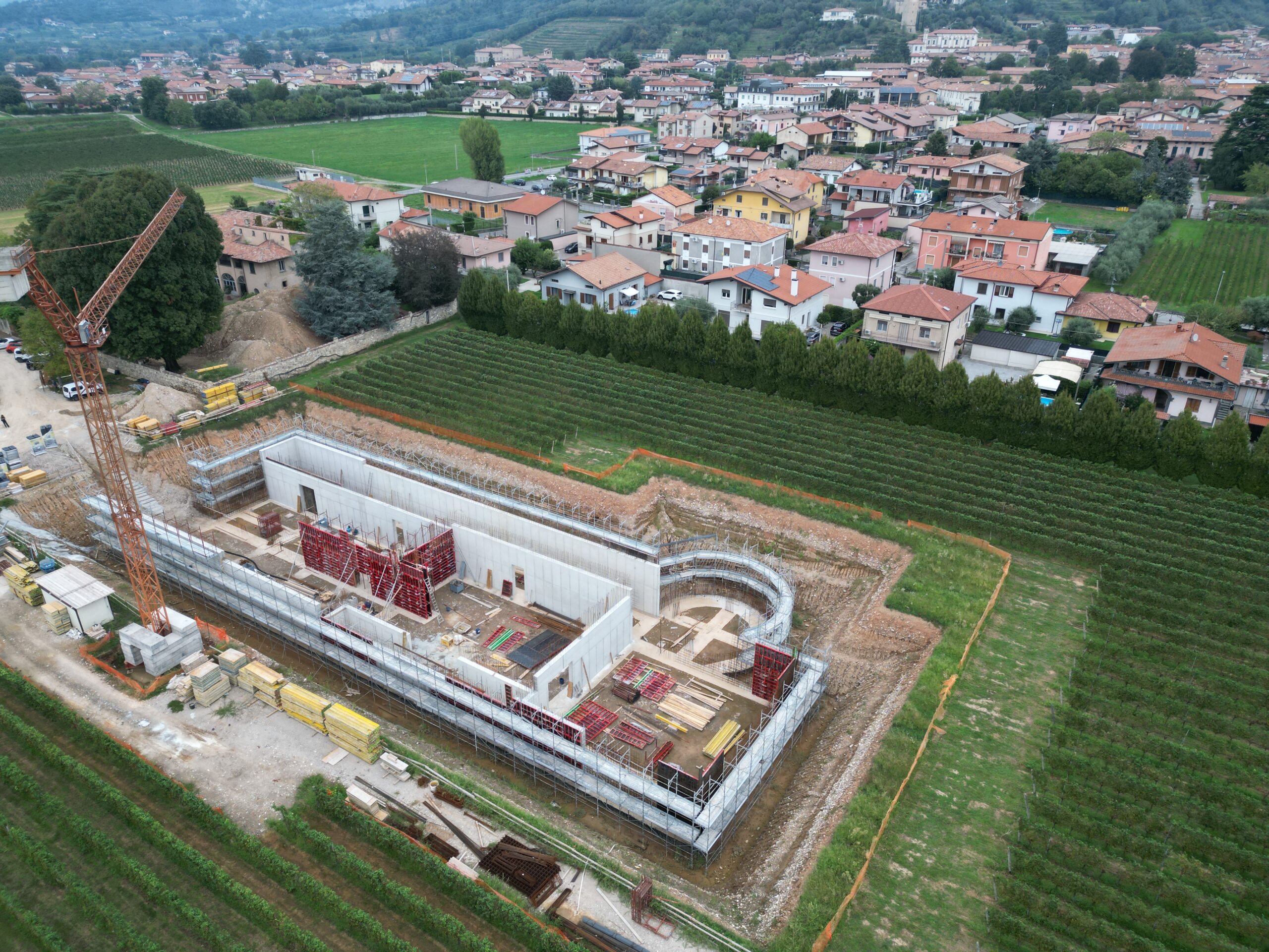 Cantiere cantina ad Adro: struttura in elevazione tra i vigneti, ripresa da drone