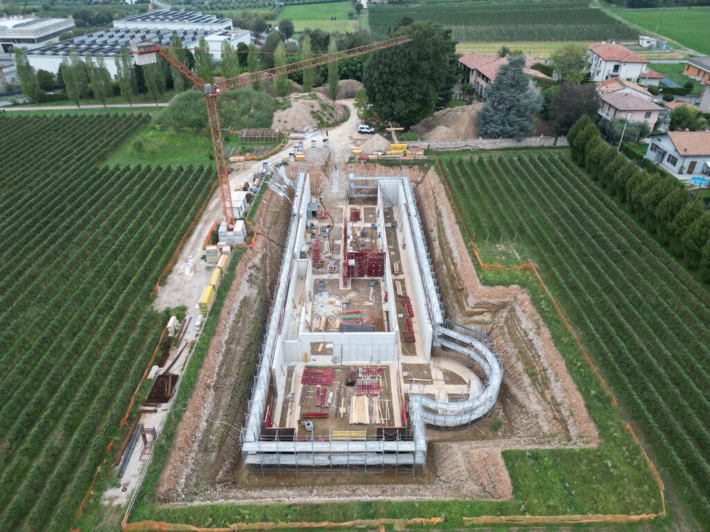 Cantiere cantina ad Adro: fronte lungo della struttura in cemento, ripresa da drone